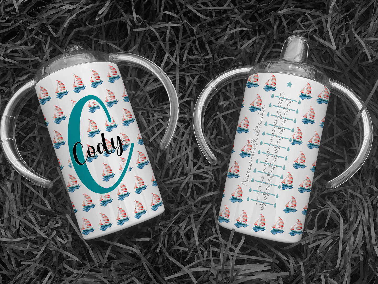 White Adult sippy cup with sailing boat design and inital and name, adaptive cup with Spouted lid for adults with disabilities. Image shows 2 matching cups on black background front and back of cup. Front of cup shows sailing boat pattern and Large Initial with name across the middle. Back shows sailing boat design with an approximate fluid amount guide to roughly track how much user is drinking.
