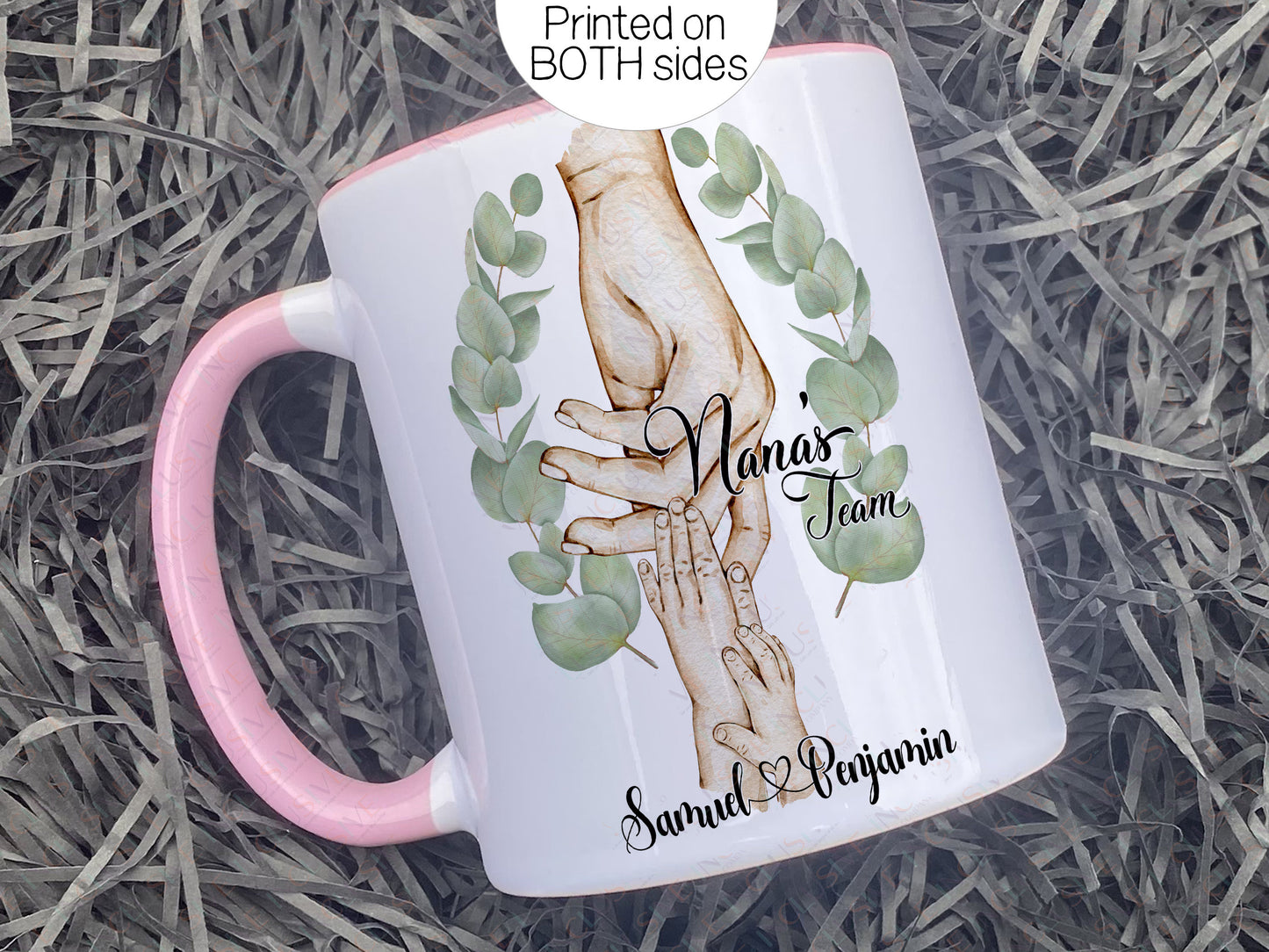 Ceramic mug with pastel pink handle and rim. Printed with watercolour style artwork of adult female hand and 2 childrens hands