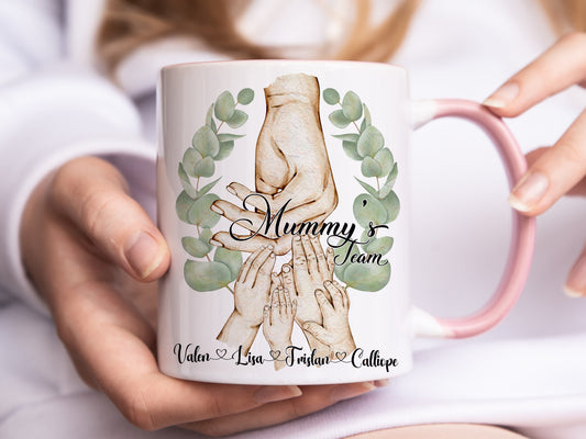 Ceramic mug with pastel pink handle and rim. Printed with watercolour style artwork of adult female hand and childrens hands option of 1-4 kids
