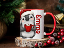 Load image into Gallery viewer, White Ceramic mug with a festive red rim and handle printed with a cheerful little Penguin holding a mug of steaming hot chocolate and Marshmallows peeking back at you. His festive red Christmas hat perched cheekily on his head. Personalised with any name and printed on both sides. Also available in plain white
