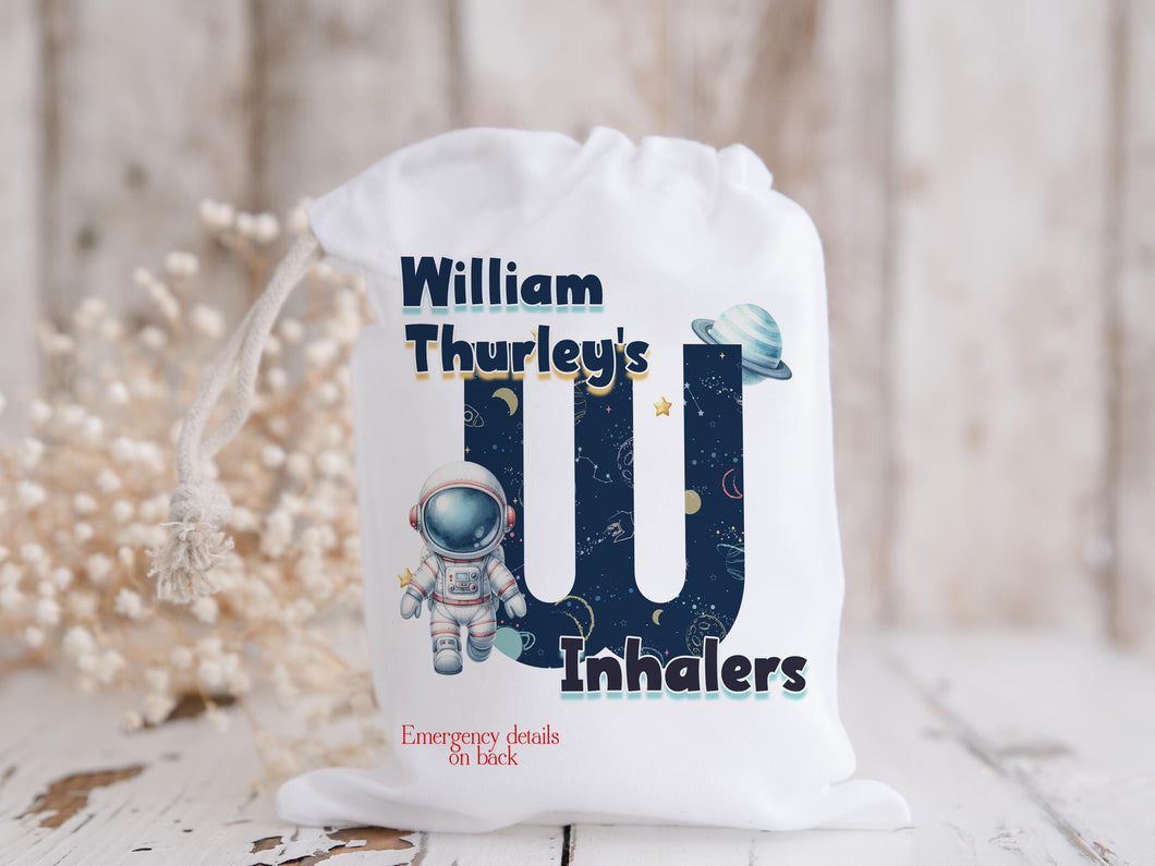 White drawstring bag. Printed with Initial of first name in a space theme with astronaut & text reading name's inhaler if you choose to have emergency contact on back it will state this is available on the front.