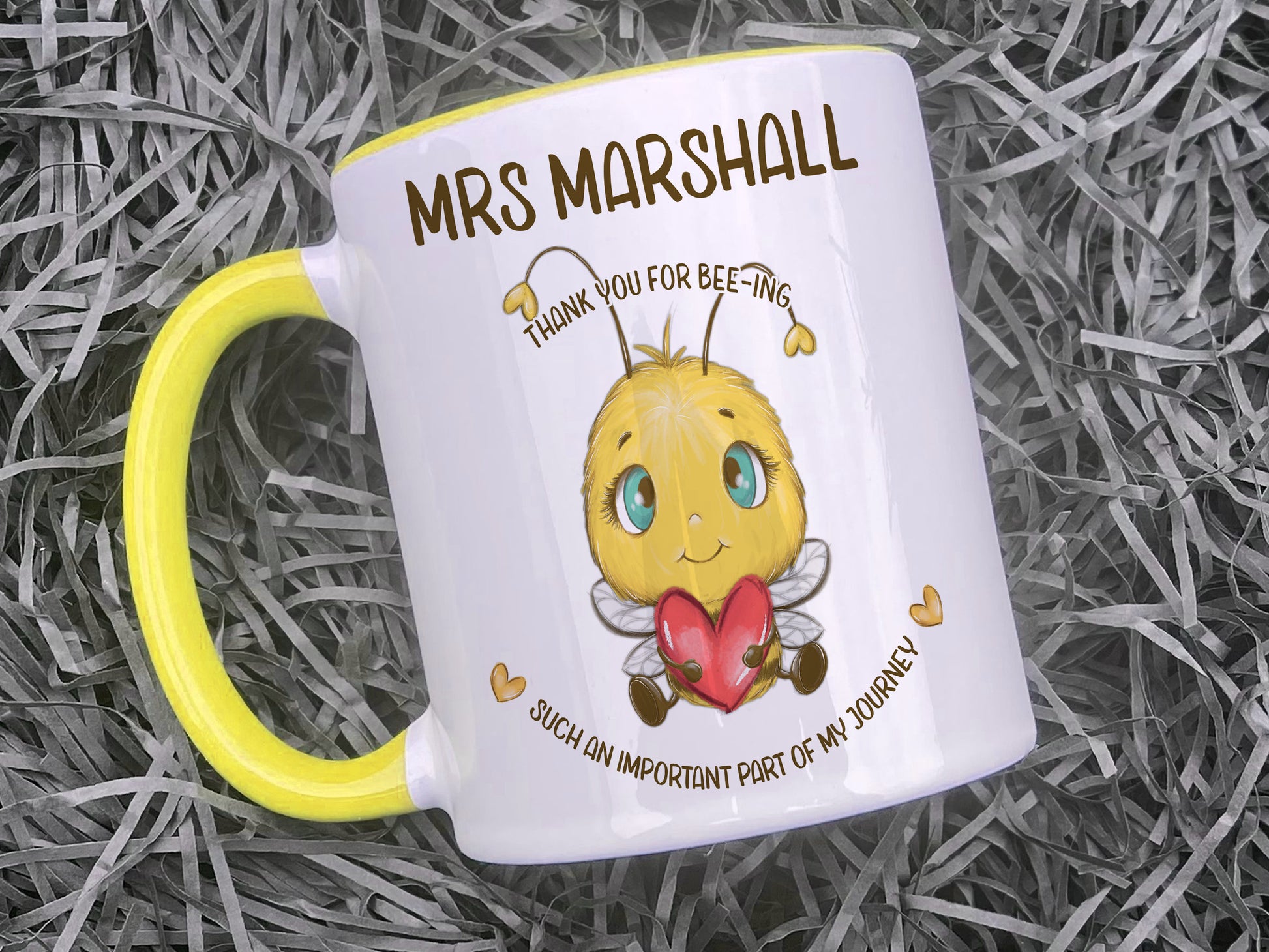 Ceramic mug with yellow handle and rim. A cute cartoon style bee holding a heart sits in the centre of the mug with the words Thank you for bee-ing such an important part of my journey and personalised with any name.
