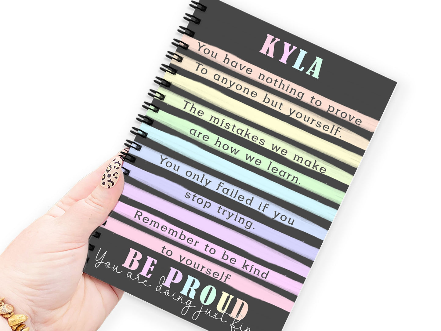 hand holding A5 black and pastel rainbow stripes notebook with positive affirmations and any name added.