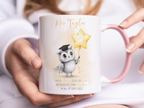 A white mug with lighter pink rim and handle. An adorable owl with a teacher cap holding a gold balloon design and Grey and gold verse is printed directly on the mug so will not fade. Available with or without personalisation.
Verse reads 
Name. 
Oh so clever, ever so wise 
an absolute star teacher
in all of our eyes.