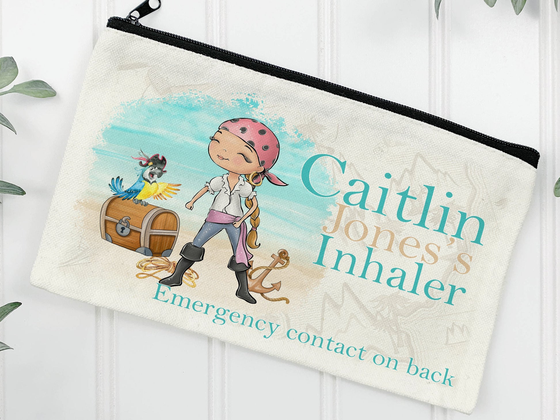 Cream Linen pouch with black zipper with a feminine pirate wearing a bandana standing on the beach with chest and parrot. Text reads Name's Inhaler.