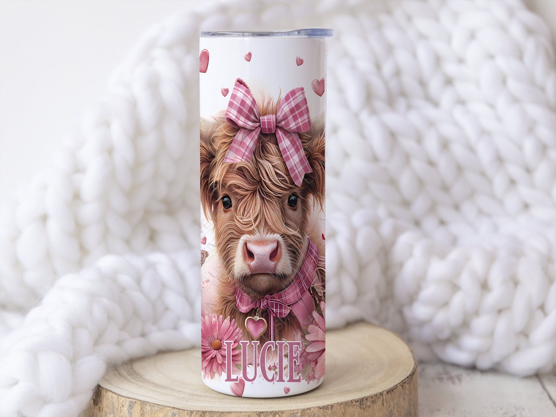 20oz white stainless teel tumbler with a realistic baby highland cow image with pink chequered hairbow and collar, pink flowers and hearts complete the design which wraps around the cup. Matching pink text for name can be added to bottom of tumbler