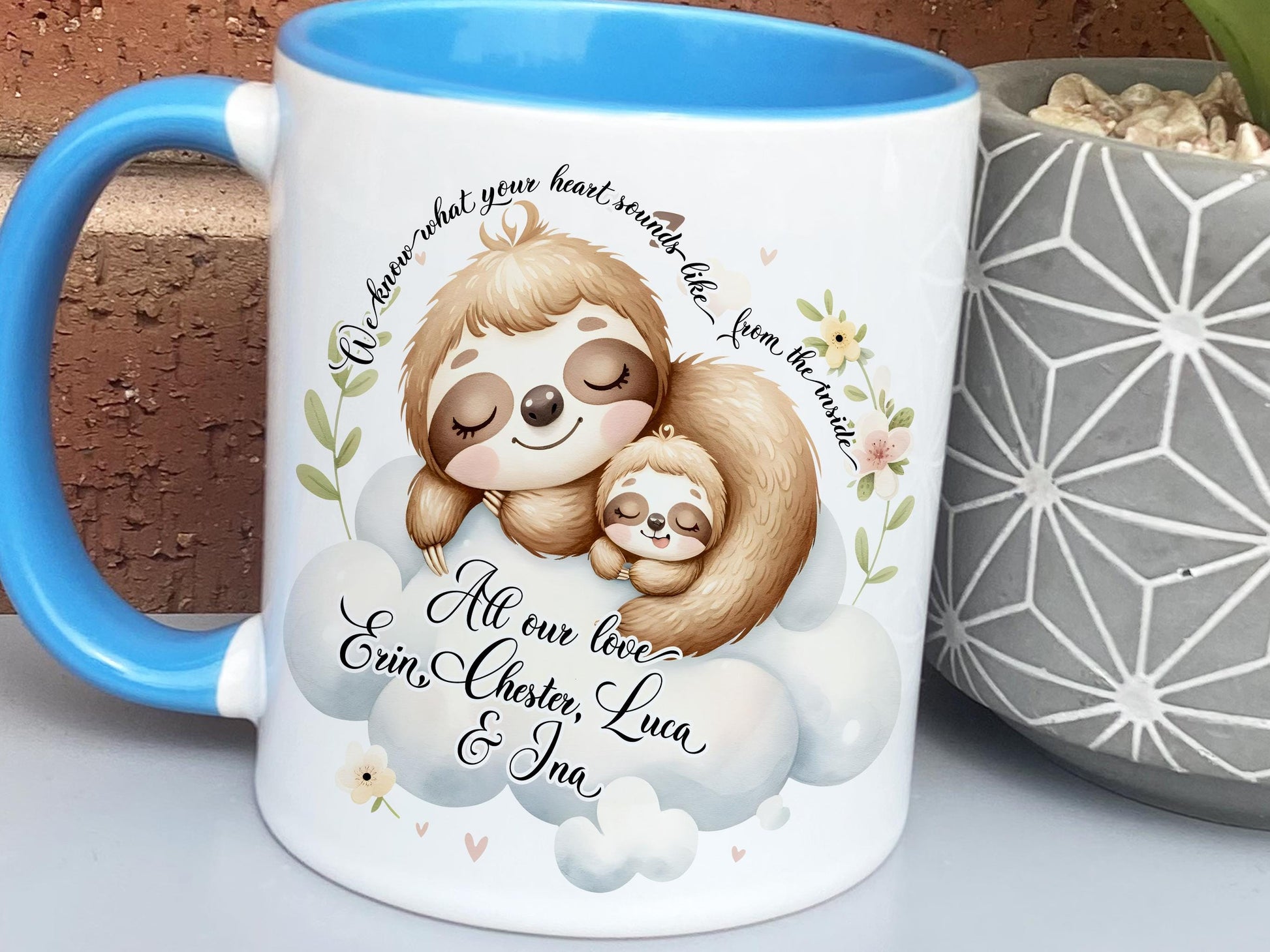 White ceramic mug with glossy blue handle, rim and inner. Design shows A cute mummy and baby sloth curled up sleeping.

Text at top of mug read I know what your heart sounds like from the inside. Add a personalised message & title of your choice.