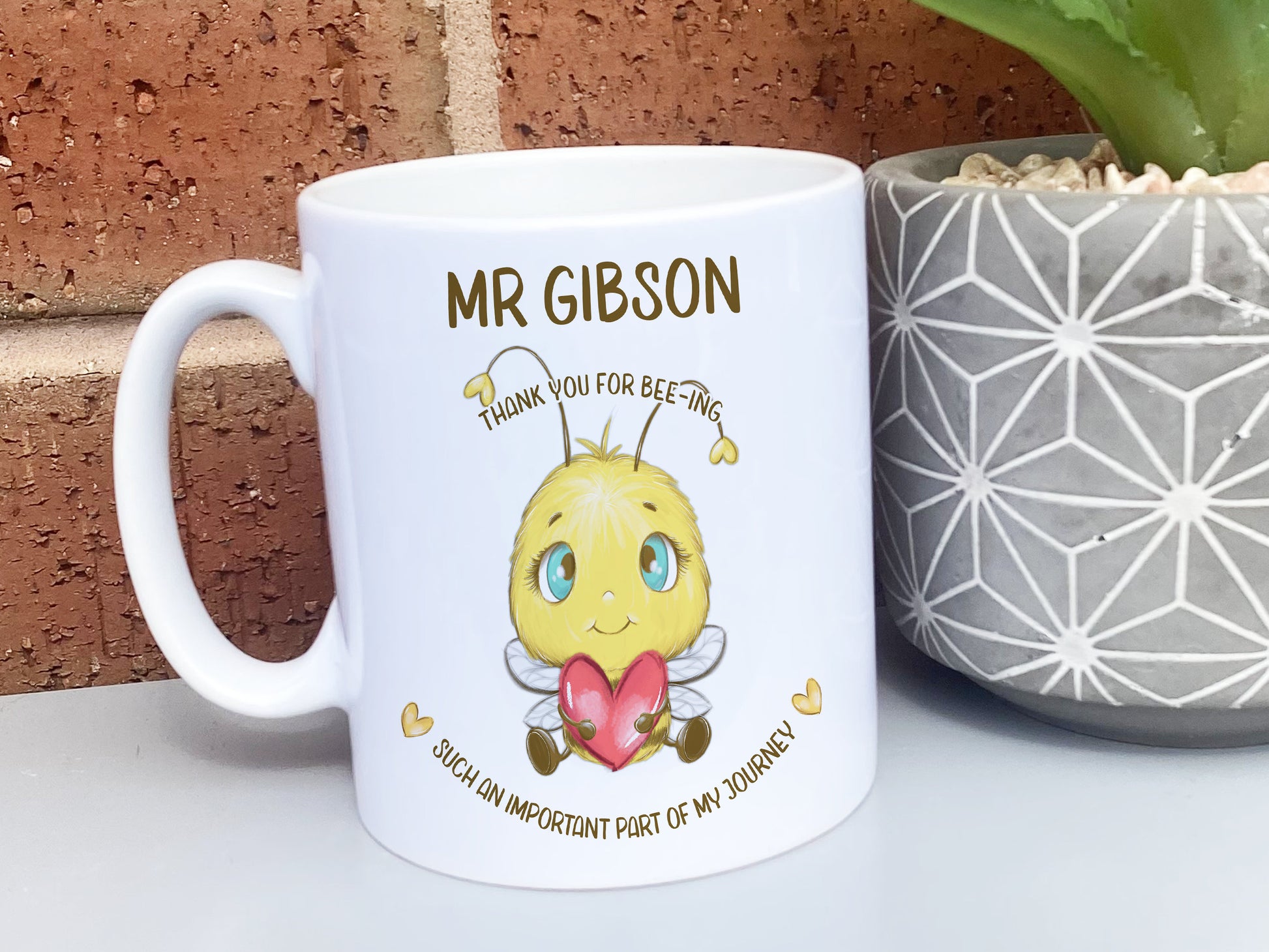 Plain white Ceramic mug. A cute cartoon style bee holding a heart sits in the centre of the mug with the words Thank you for bee-ing such an important part of my journey and personalised with any name.
