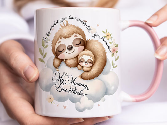 White ceramic mug with glossy pink handle, rim and inner. Design shows A cute mummy and baby sloth curled up sleeping.

Text at top of mug read I know what your heart sounds like from the inside. Add a personalised message & title of your choice.