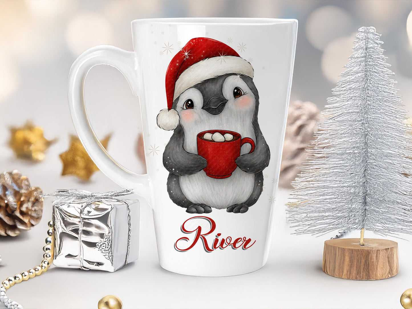 Large tapered Latte style White ceramic mug with a cute, friendly penguin in a red Christmas hat and holding a steaming drink topped with marshmallows and the name River printed at the bottom. Any name can be printed.
