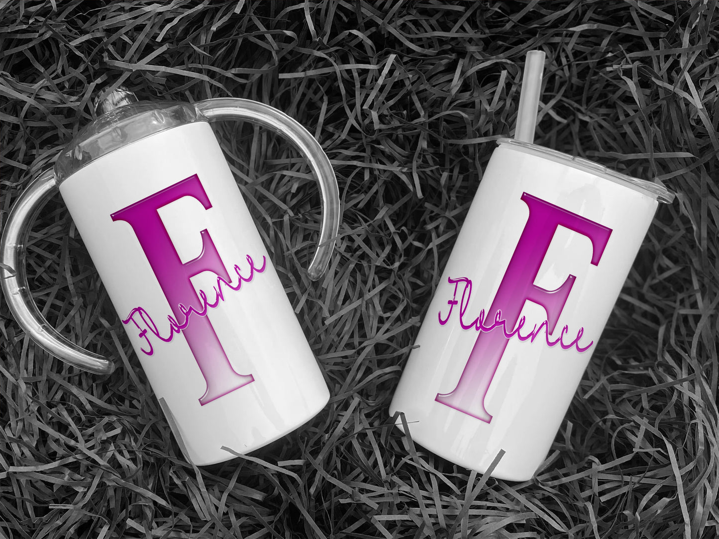White Stainless steel Sippy cup with clear plastic lid with spout and large handles. A glossy Pink and white Initial with Name in script written across in matching pink.  An additional flat lid with no handles and straw is supplied.