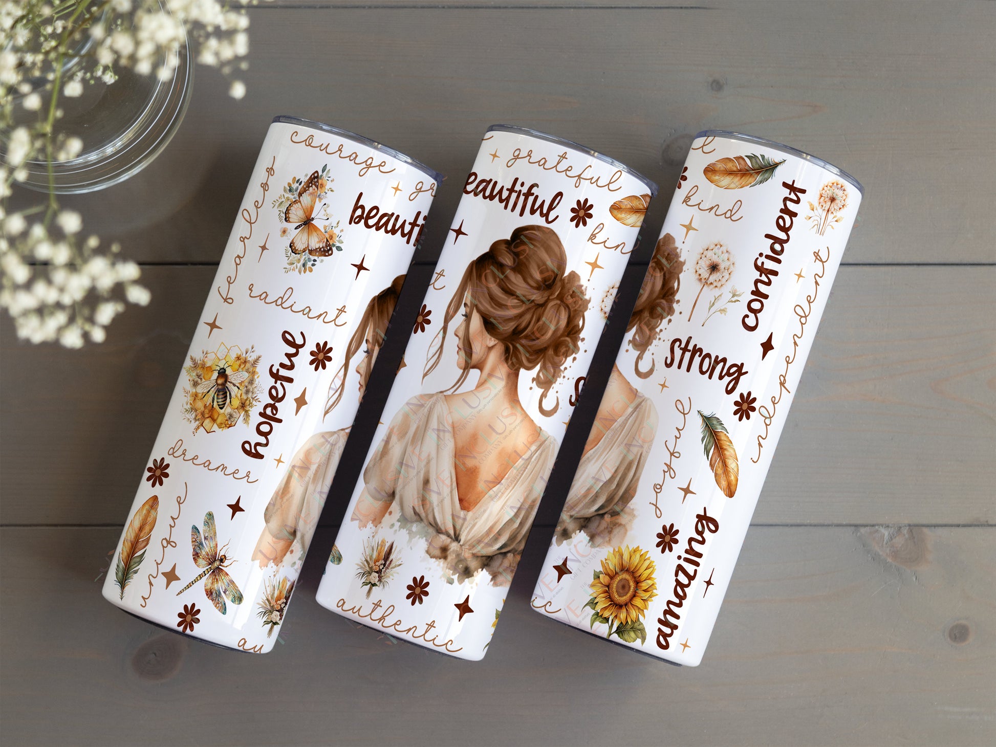 20oz white stainless steel tumbler with the back view of an elegant brunette woman surrounded by nature images and descriptive, inspirational words like unique, dreamer, fearless, radiant, authentic and confident in browns and beige colours