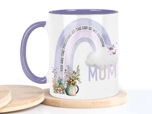 White ceramic mug with glossy purple handle, rim and inner. Design shows A purple and pink coloured rainbow with flowers and watering can at one end, cloud & butterflys at the other. 

Text reads Mum You are the treasure at the end of my rainbow.