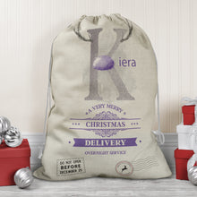 Load image into Gallery viewer, Large natural looking Linen Sack with printed Reindeer antler and Silver Initial letter with lilac coloured nose &amp; text Name is written in lilac above the words A very merry Christmas Delivery Overnight service and two North pole style delivery stamp

