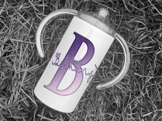 White Stainless steel Sippy cup with clear plastic lid with spout and large handles. A glossy Purple and white Initial with Name in script written across in matching purple.