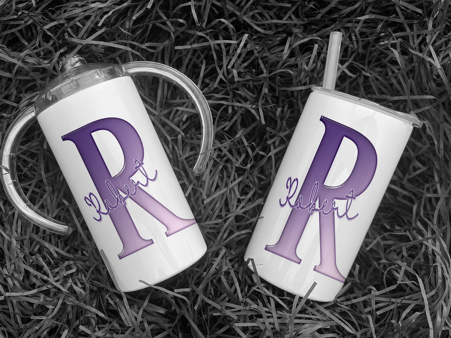 White Stainless steel Sippy cup with clear plastic lid with spout and large handles. A glossy Purple and white Initial with Name in script written across in matching purple.  An additional flat lid with no handles and straw is supplied.