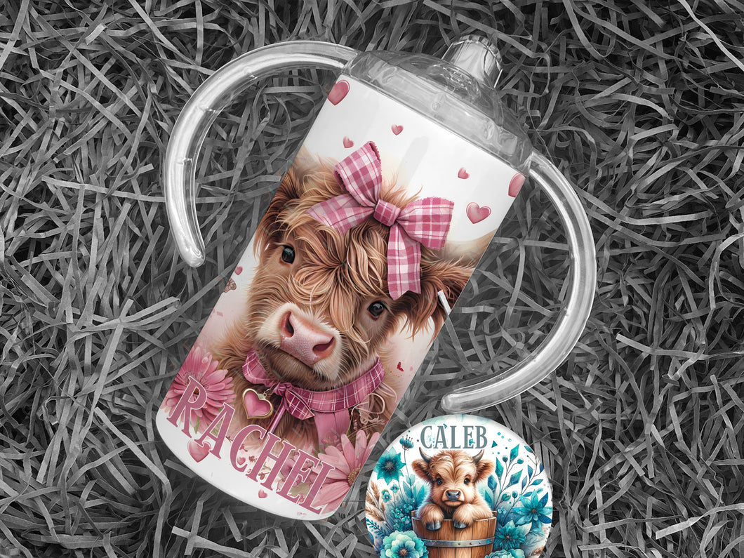 A fluffy highland cow calf with gingham pink and white collar and bow surrounded by pink wild flowers on a white 12 oz sippy cup Also available as highland cow in wooden tub surrounded by blue wild flowers.